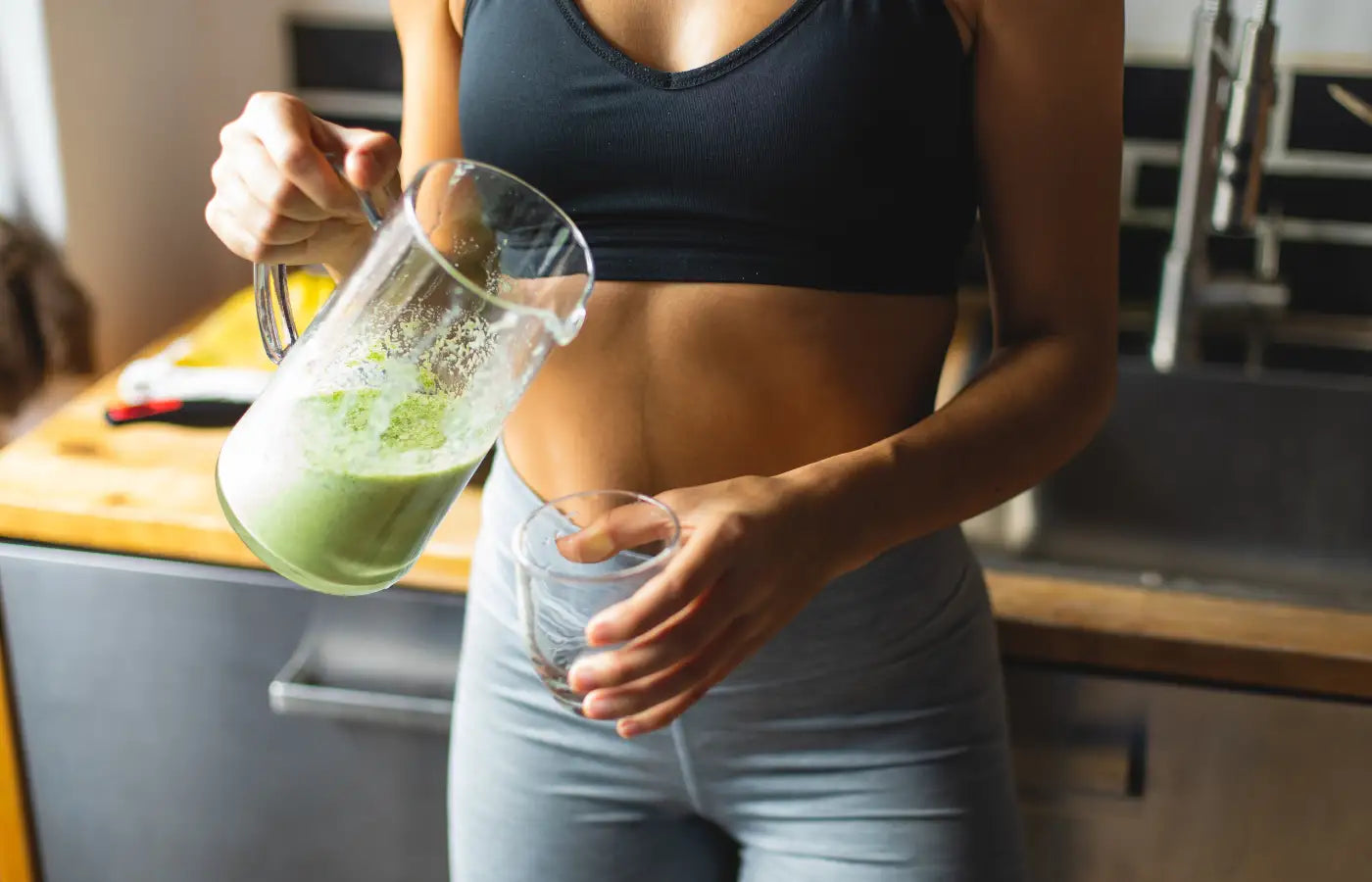 Kvinne heller probiotisk BioFedora-drikke i glasset sitt som del av en sunn smoothie – illustrerer hvordan BioFedora brukes i hverdagen